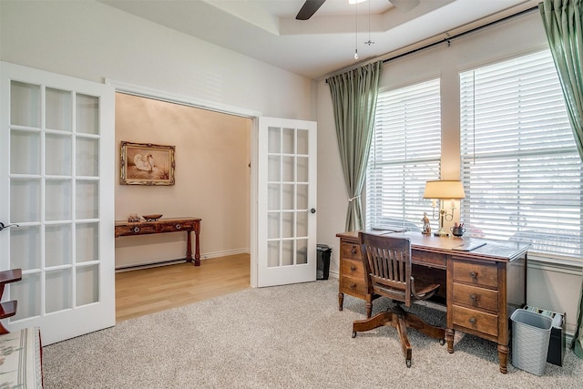 carpeted office featuring ceiling fan, a raised ceiling, and french doors