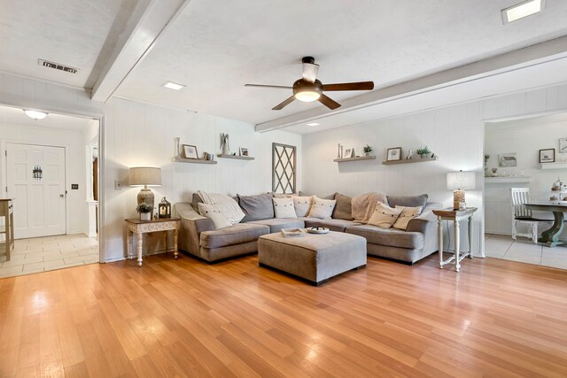 living room with hardwood / wood-style floors, ceiling fan, and beam ceiling