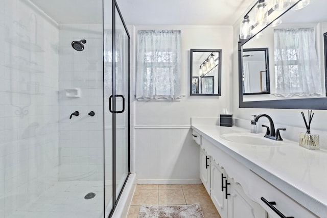 bathroom with tile patterned flooring, vanity, a shower with door, and ornamental molding