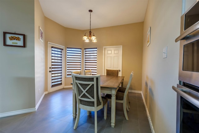 dining room with a chandelier and dark tile patterned floors