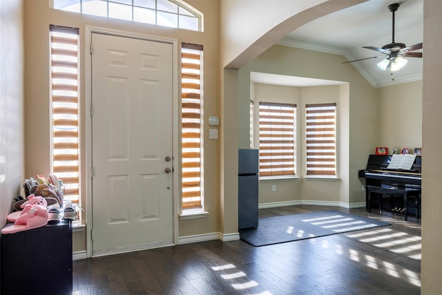 entryway featuring vaulted ceiling, ceiling fan, ornamental molding, and dark hardwood / wood-style flooring