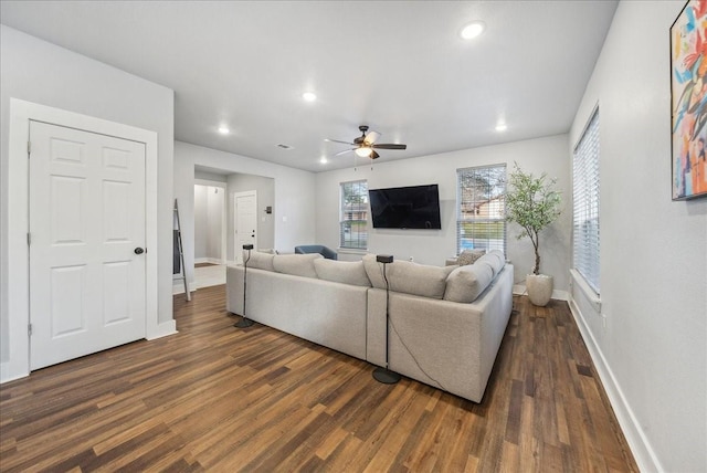 living room featuring ceiling fan and dark hardwood / wood-style flooring