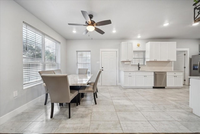 tiled dining area featuring ceiling fan and sink