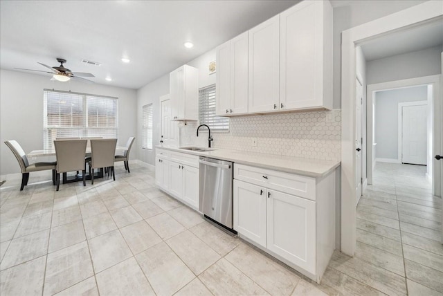 kitchen with white cabinets, stainless steel dishwasher, ceiling fan, and sink