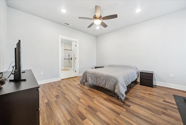 bedroom with hardwood / wood-style floors, ensuite bathroom, and ceiling fan