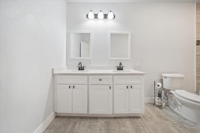 bathroom with hardwood / wood-style floors, vanity, and toilet