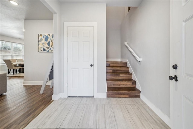 stairway featuring wood-type flooring and a textured ceiling