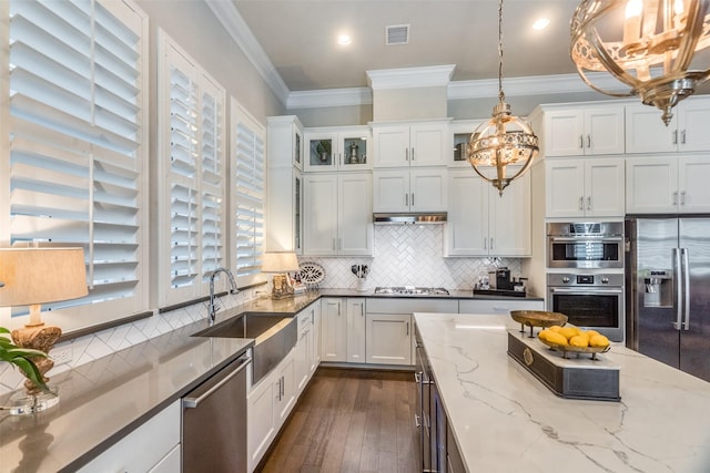 kitchen with white cabinetry, sink, light stone counters, pendant lighting, and appliances with stainless steel finishes