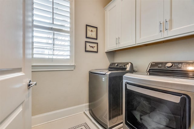 laundry room with washing machine and dryer and cabinets