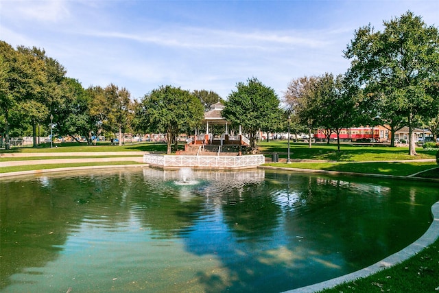 view of property's community with a gazebo, a yard, and a water view