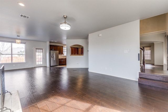 unfurnished living room featuring a barn door and dark wood-type flooring