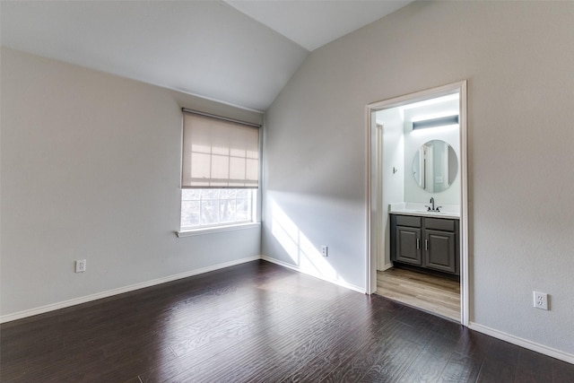 unfurnished room featuring dark hardwood / wood-style flooring, lofted ceiling, and sink