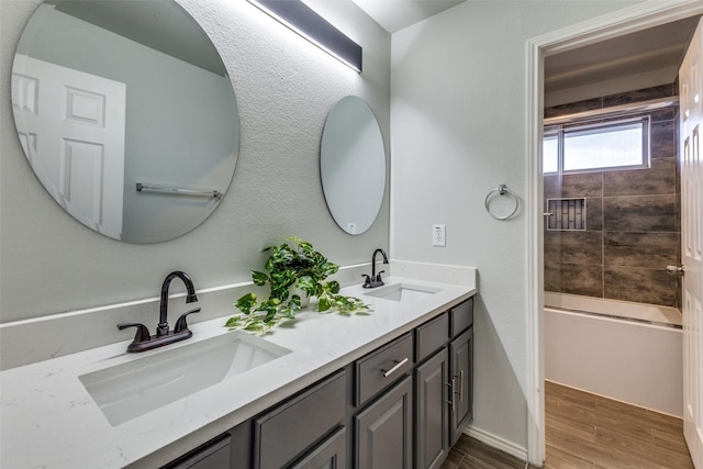 bathroom featuring vanity, wood-type flooring, and tiled shower / bath