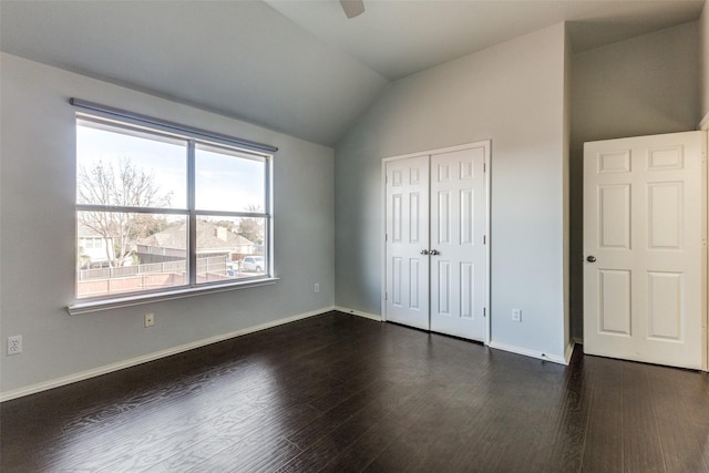 unfurnished bedroom featuring ceiling fan, dark hardwood / wood-style floors, vaulted ceiling, and a closet