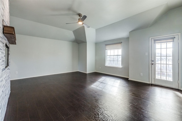 interior space featuring a fireplace, vaulted ceiling, ceiling fan, and a healthy amount of sunlight