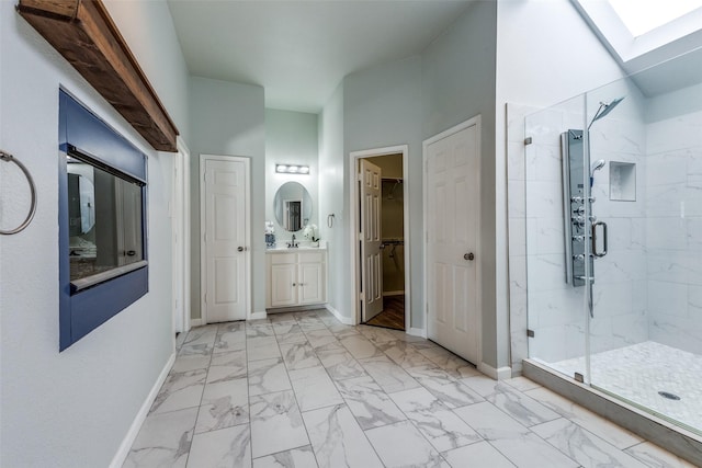 bathroom with vanity, a skylight, and a shower with door