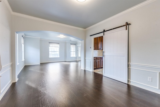 unfurnished living room featuring wood-type flooring, a barn door, and crown molding