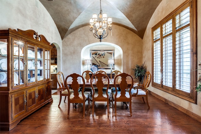 dining room featuring an inviting chandelier, lofted ceiling, and dark hardwood / wood-style floors