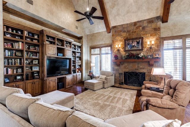 living room featuring a stone fireplace, high vaulted ceiling, beamed ceiling, hardwood / wood-style flooring, and ceiling fan