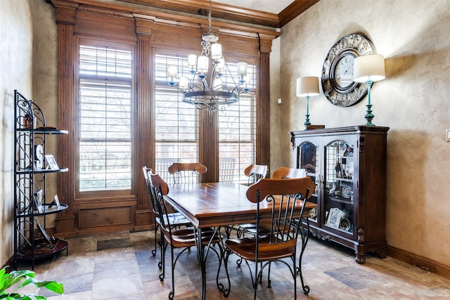 dining area with crown molding, a healthy amount of sunlight, and a chandelier