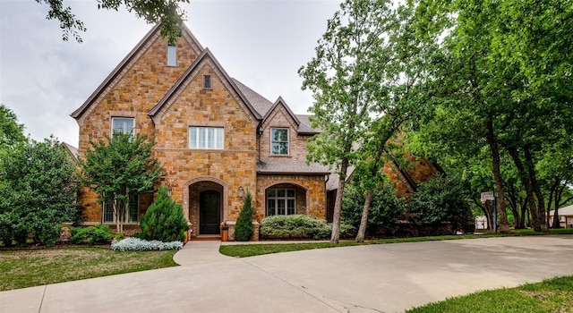 english style home featuring a front lawn