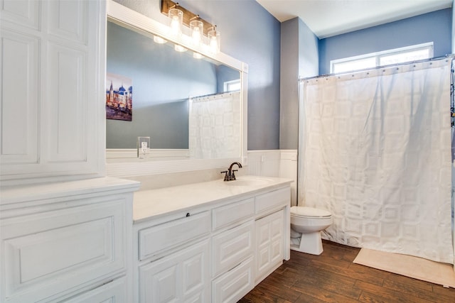 bathroom with hardwood / wood-style flooring, vanity, toilet, and walk in shower