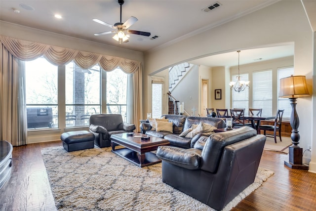 living room with crown molding, dark wood-type flooring, and a healthy amount of sunlight