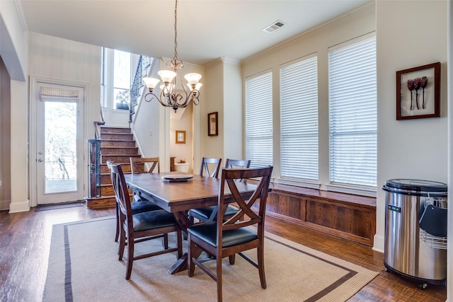 dining room with crown molding, dark hardwood / wood-style floors, and a notable chandelier