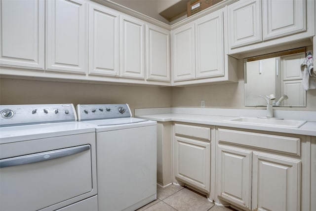 washroom featuring sink, washer and clothes dryer, cabinets, and light tile patterned flooring