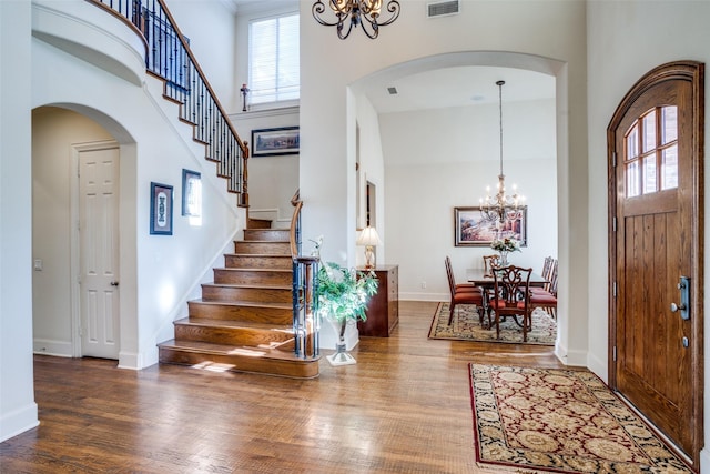 foyer featuring a high ceiling, hardwood / wood-style flooring, and a chandelier