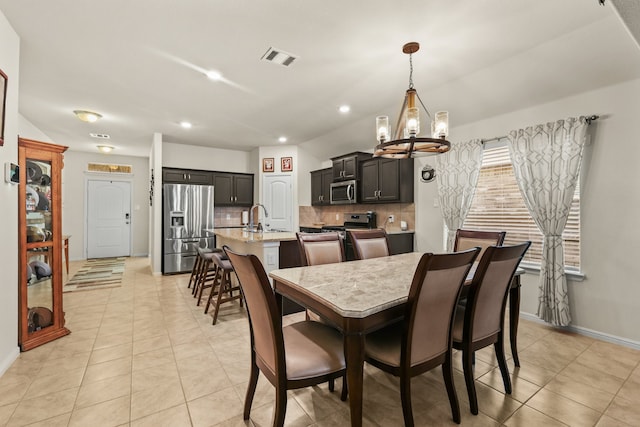 tiled dining space featuring sink and a chandelier