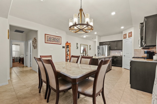 tiled dining space featuring an inviting chandelier