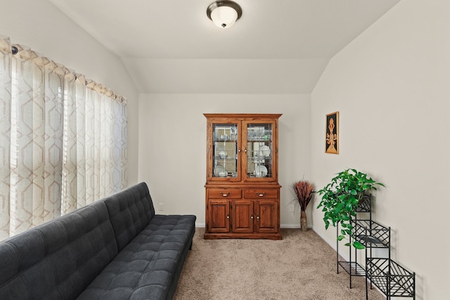 living room featuring light colored carpet and vaulted ceiling