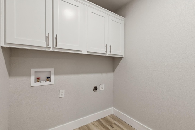 laundry room with cabinets, electric dryer hookup, hookup for a washing machine, and light wood-type flooring