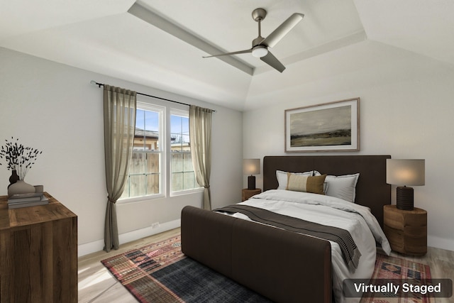 bedroom featuring a raised ceiling, ceiling fan, and light hardwood / wood-style floors