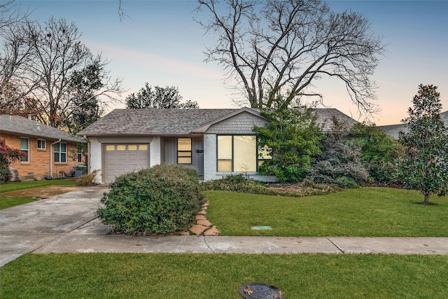 view of front of home featuring a garage and a lawn