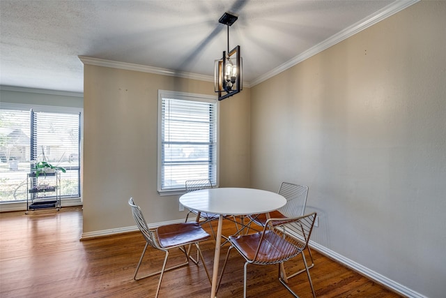 dining room featuring hardwood / wood-style flooring, ornamental molding, and an inviting chandelier