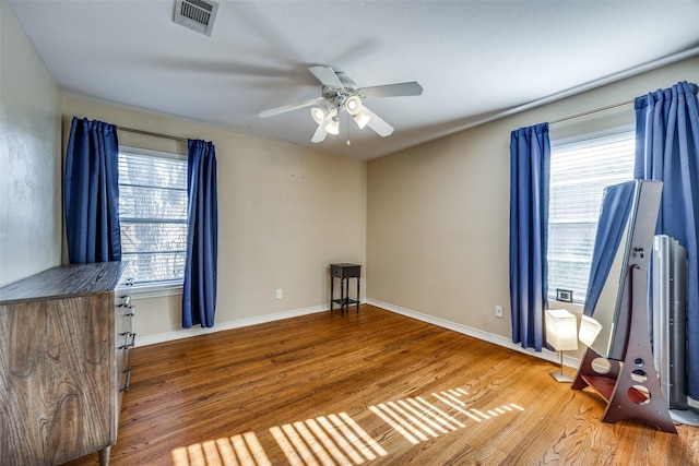 interior space with ceiling fan and wood-type flooring