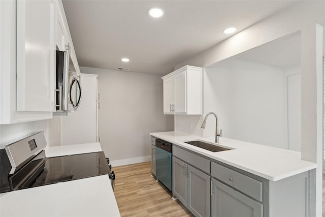 kitchen with sink, gray cabinetry, stainless steel appliances, white cabinets, and light wood-type flooring