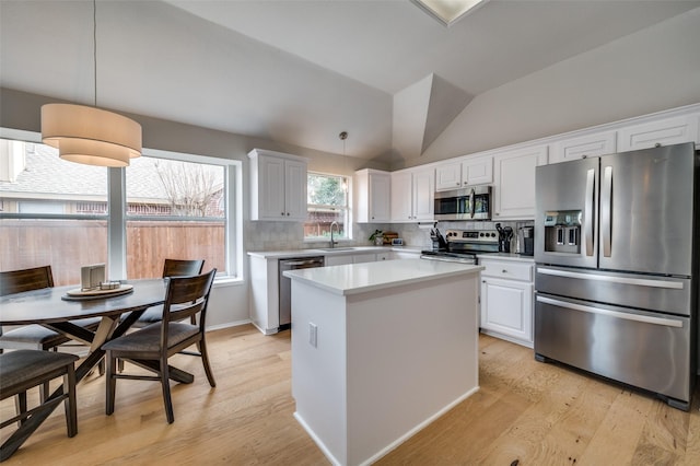 kitchen featuring appliances with stainless steel finishes, tasteful backsplash, sink, pendant lighting, and white cabinetry