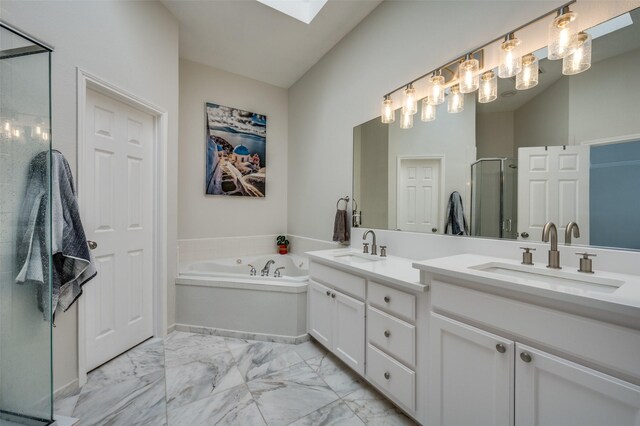 bathroom featuring shower with separate bathtub, vanity, and vaulted ceiling with skylight