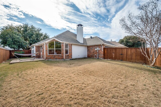 rear view of property with a lawn and a patio