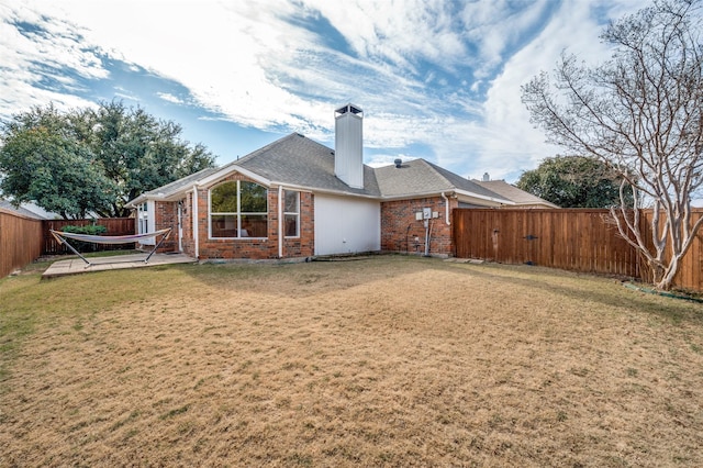 rear view of house featuring a patio area and a lawn