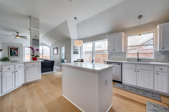 kitchen featuring pendant lighting, sink, stainless steel dishwasher, decorative backsplash, and white cabinetry