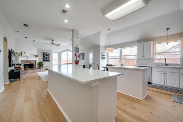 kitchen with white cabinets, ceiling fan, a center island, and pendant lighting