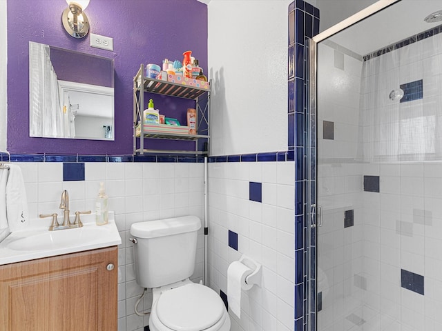 bathroom with vanity, toilet, an enclosed shower, and tile walls