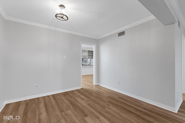 unfurnished room with hardwood / wood-style flooring and ornamental molding