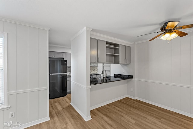 kitchen with ceiling fan, light hardwood / wood-style flooring, crown molding, gray cabinets, and black refrigerator