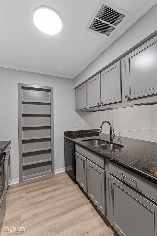 kitchen featuring black dishwasher, light hardwood / wood-style flooring, dark stone counters, and sink