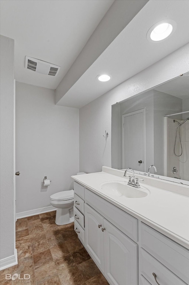 bathroom featuring vanity, toilet, and walk in shower